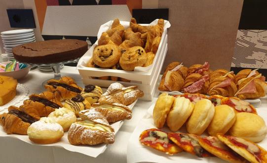Buffet di dolci e salati con croissant, torte e pizzette.