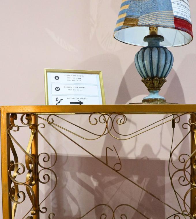 Lampada su tavolo decorato con cartello indicazioni per le stanze.
